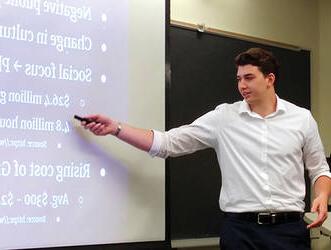 A male "Launch Your Business" program entrepreneur presenting to an audience.